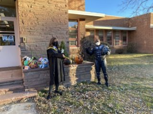 Halloween celebration carving pumpkins in front of school