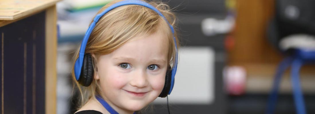 Student posing in class wearing headphones